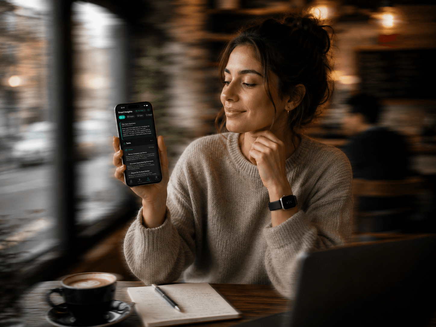 Woman smiling at the Sonal app on her phone in a cafe
